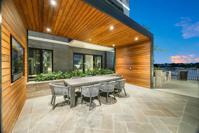 Elegant outdoor dining area with modern wooden accents, spacious seating, and stunning evening views.