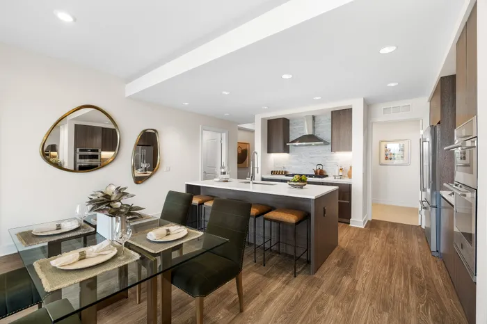 Elegant open-plan kitchen and dining area featuring modern appliances, chic decor, and a spacious island with seating.