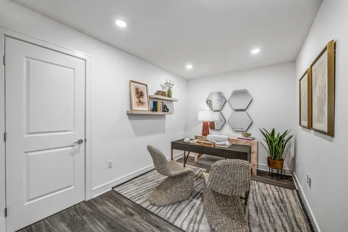 Chic home office with modern decor, featuring hexagonal mirrors, stylish wicker chairs, and warm wooden accents.