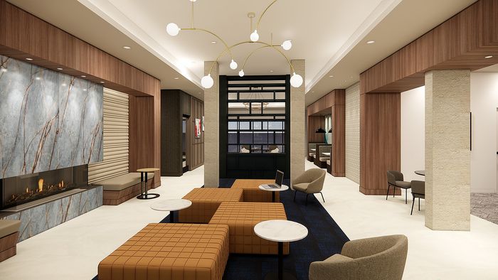 Elegant apartment lounge area featuring modern seating, a striking marble fireplace, and ambient lighting for a cozy atmosphere.