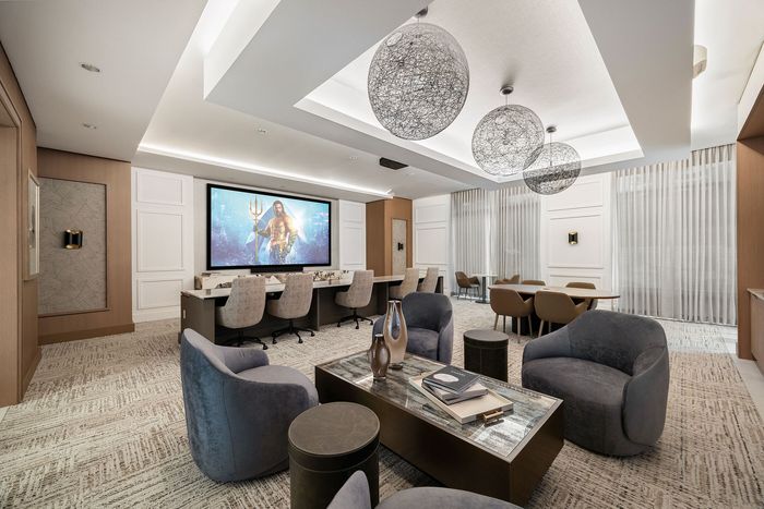 Luxurious home theater room with modern seating, stylish decor, and a large screen for an immersive entertainment experience.