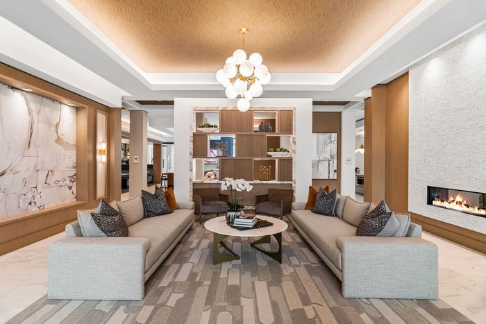 Luxurious living room with modern decor, featuring plush sofas, a chic chandelier, and a cozy built-in fireplace.