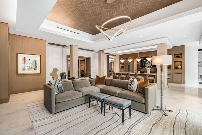 Elegant and spacious living area featuring a modern sectional sofa, stylish pendant lighting, and a contemporary open-plan design, perfect for luxurious urban living.