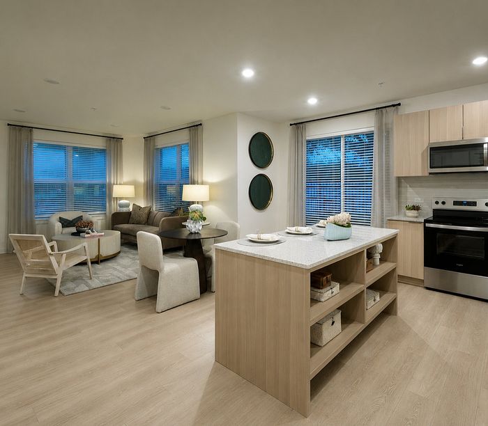 Modern open-concept apartment featuring a stylish kitchen island, cozy living area with elegant decor, and abundant natural light.