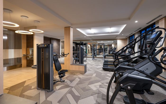 Modern fitness center featuring state-of-the-art exercise equipment, elegant lighting, and spacious design.