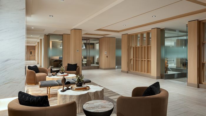 Luxurious apartment lobby featuring elegant seating, stylish decor, and modern wooden paneling.