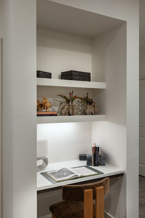 Elegant built-in desk nook with stylish shelving, decorative vases, and books, ideal for a modern home office.