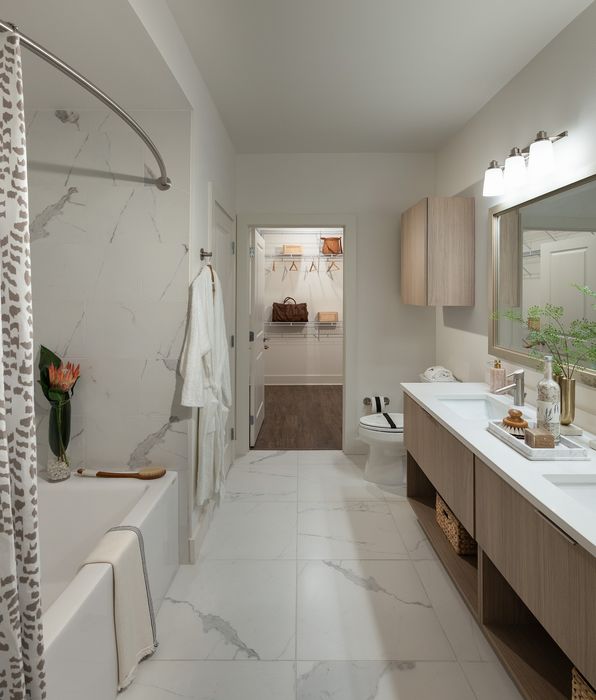 Luxurious bathroom with elegant marble tiles, modern fixtures, and a spacious walk-in closet.
