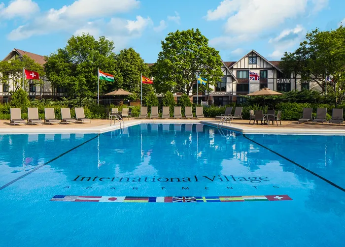 Dive into relaxation in our sparkling swimming pool surrounded by premium deck furniture and refreshing shade structures. |  International Village Lombard |  International Village Lombard Apartments