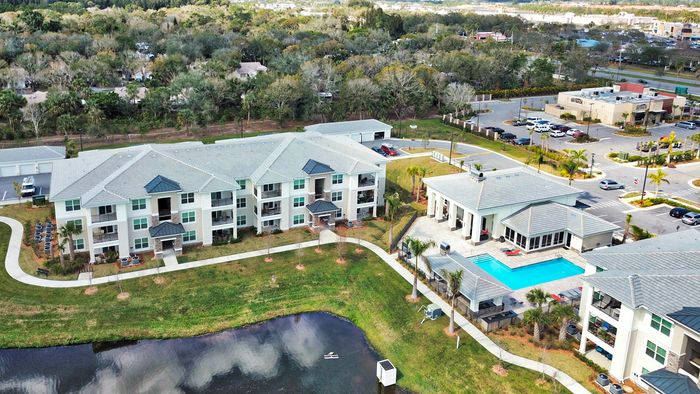 The Reserve at Vero Beach, exterior, aerial view of pond, clubhouse, pool, apartment buildings