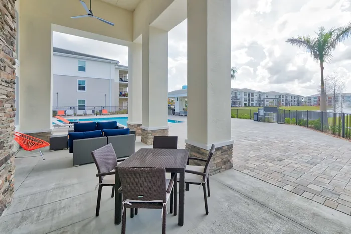 The Reserve at Vero Beach, exterior, outdoor covered seating, sparkling blue swimming pool, palm tree, building exteriors