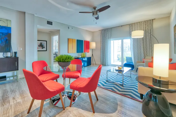 The Reserve at Vero Beach, interior, open concept, dining room, living room, ceiling fan, large sliding glass doors, wood floors