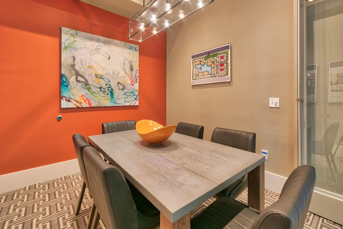 The Reserve at Vero Beach, interior, conference room, orange accent wall, dining table, chairs