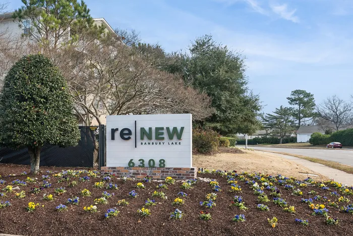 Entrance of Renew Banbury Lake with signage and colorful flower garden.