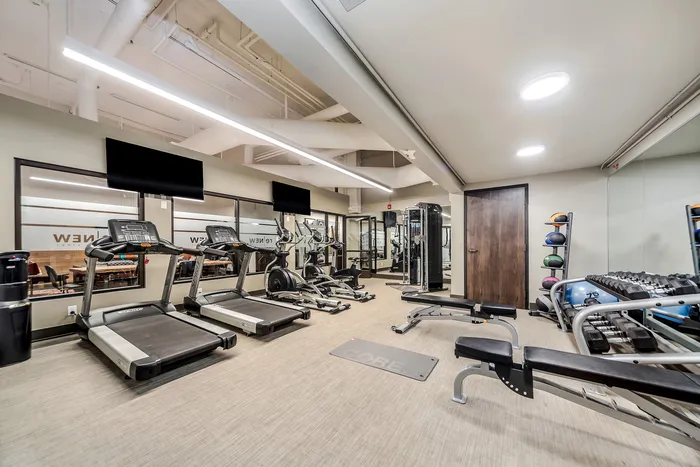 Modern fitness center in an apartment complex featuring state-of-the-art equipment and sleek design.