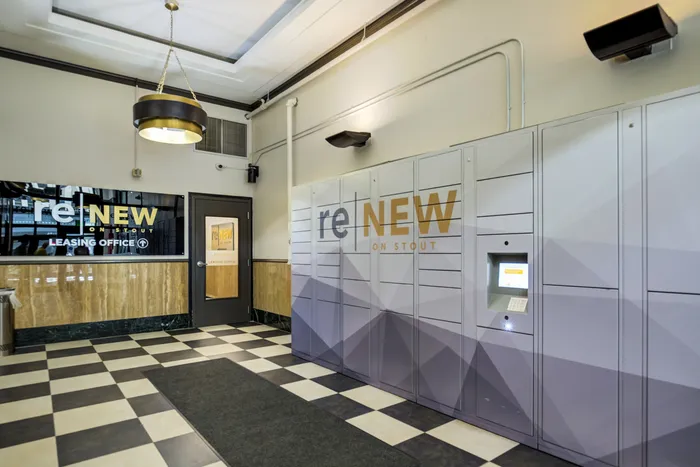 Chic apartment lobby at ReNew On Stout with modern parcel lockers and stylish design.