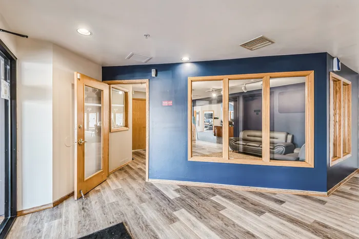 Inviting lounge area with wooden flooring, blue accent wall, and modern decor.