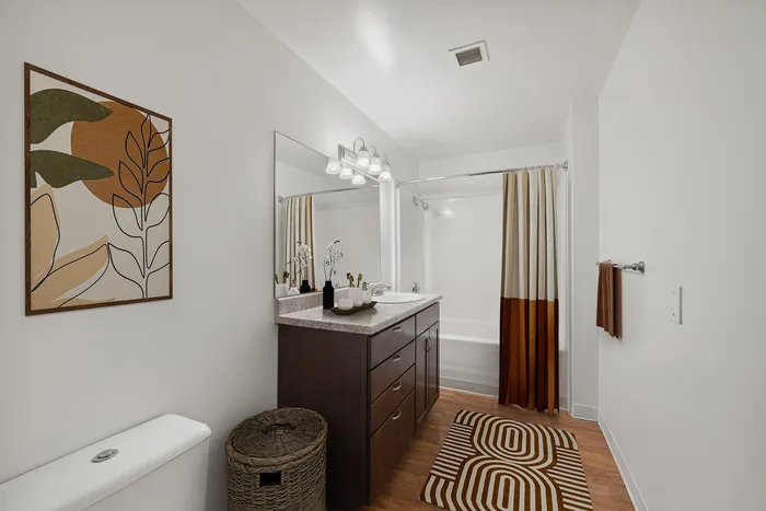 Contemporary bathroom featuring elegant vanity, unique artwork, and earth-toned accents.