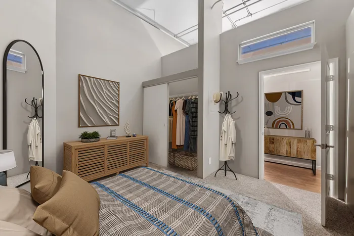 Modern bedroom with stylish decor, featuring a textured wall art, a spacious wardrobe, and soft lighting.