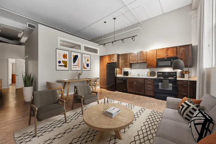 Sleek, modern living space featuring a stylish open-concept kitchen, dining area, and cozy living room with chic decor.