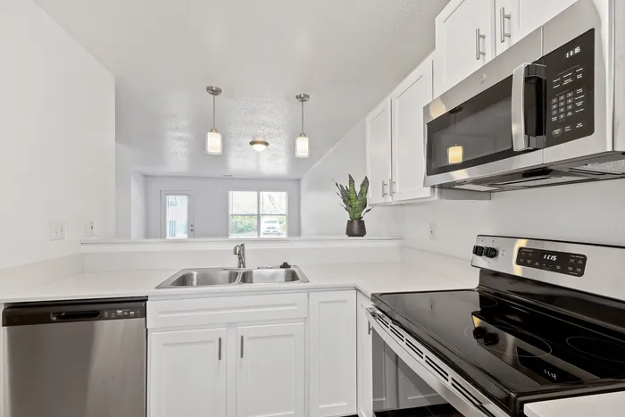 Open-concept kitchen with sleek cabinetry, stainless steel appliances, and elegant lighting.