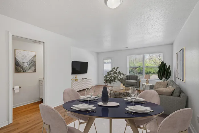 Bright open living room with modern decor, featuring a cozy seating area and elegant dining setup.