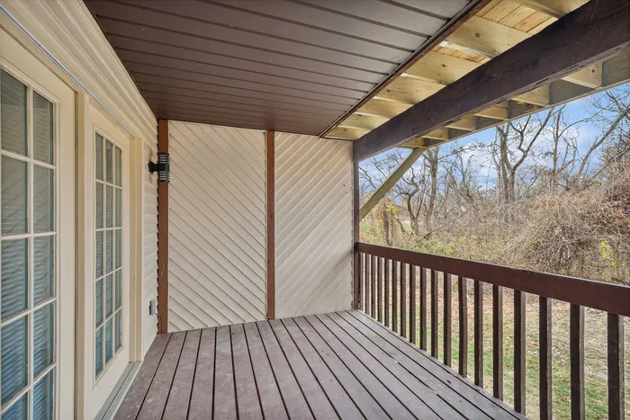 Inviting outdoor balcony with wooden flooring and natural views.