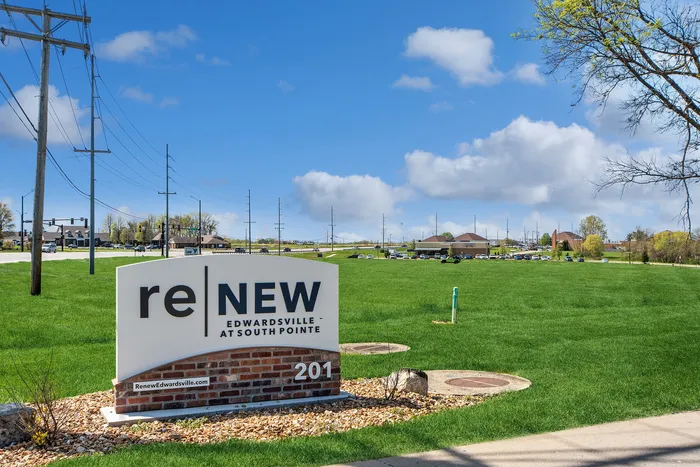 Bright day view of Renew Edwardsville entrance sign surrounded by lush green landscape.