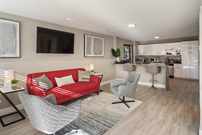 ReNew Foothills Modern apartment with red sofa, stylish kitchen, and open living space.