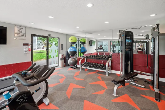 ReNew Foothills Modern apartment fitness center featuring various exercise equipment, free weights, and vibrant decor.