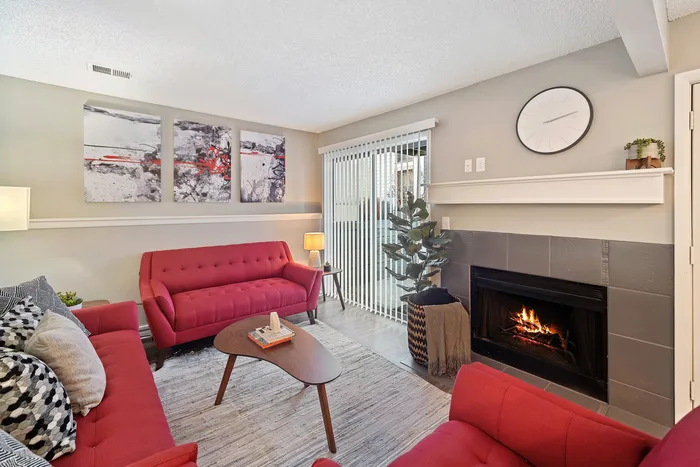 ReNew Foothills Inviting living room with red sofas, cozy fireplace, and modern decor.