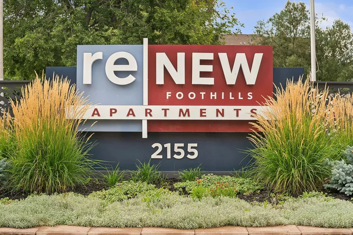 ReNew Foothills Vibrant sign for ReNew Foothills Apartments surrounded by lush green landscaping.