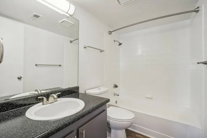 ReNew Foothills Modern bathroom with a sleek countertop, integrated sink, and tiled shower area.