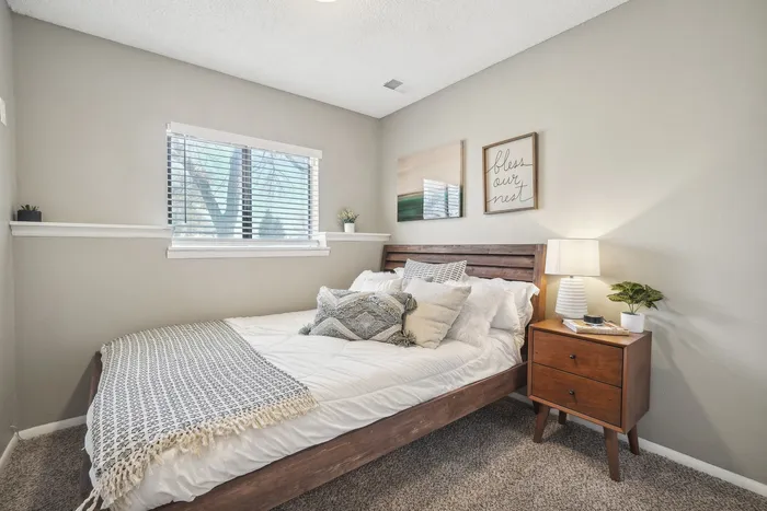ReNew Foothills Inviting bedroom with plush pillows, wooden bed frame, and stylish decor.