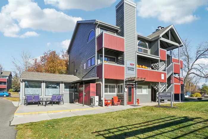 ReNew Foothills Contemporary leasing office exterior with red and gray accents and outdoor seating.