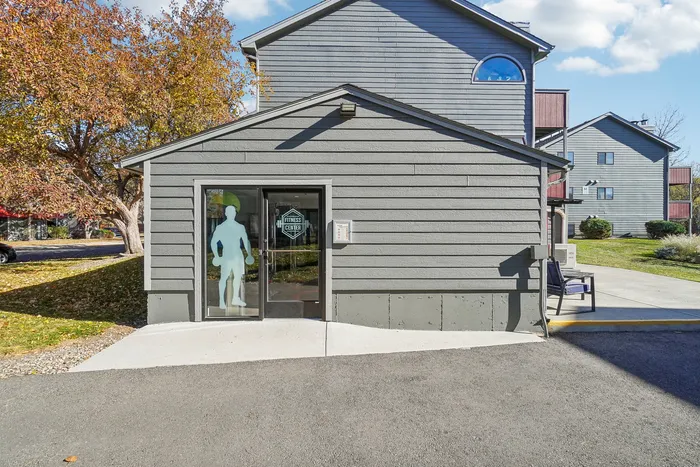 ReNew Foothills Modern fitness center entrance with stylish glass doors and vibrant autumn trees.