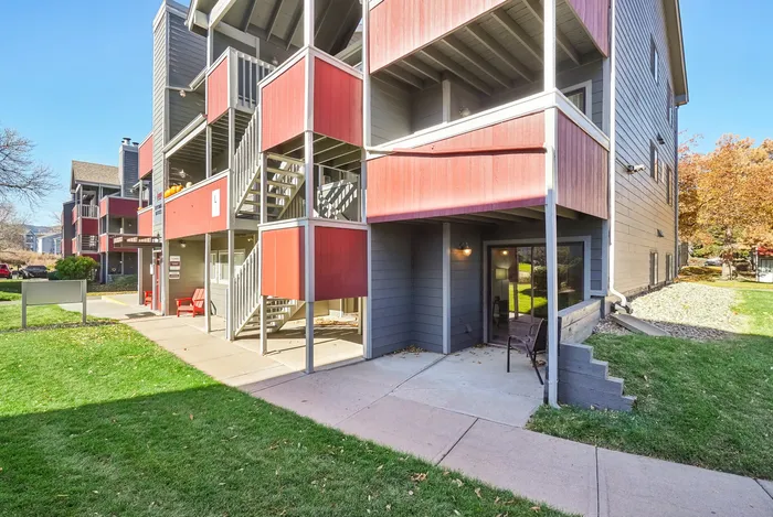 ReNew Foothills Modern apartment building with red and gray accents, featuring multiple staircases and outdoor seating.