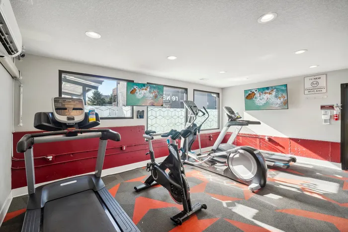 ReNew Foothills Modern fitness room featuring exercise equipment with natural light and vibrant decor.