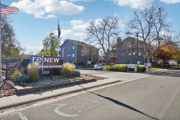 ReNew Foothills Entrance view of ReNew Foothills Apartments featuring landscaped surroundings and vibrant signage.