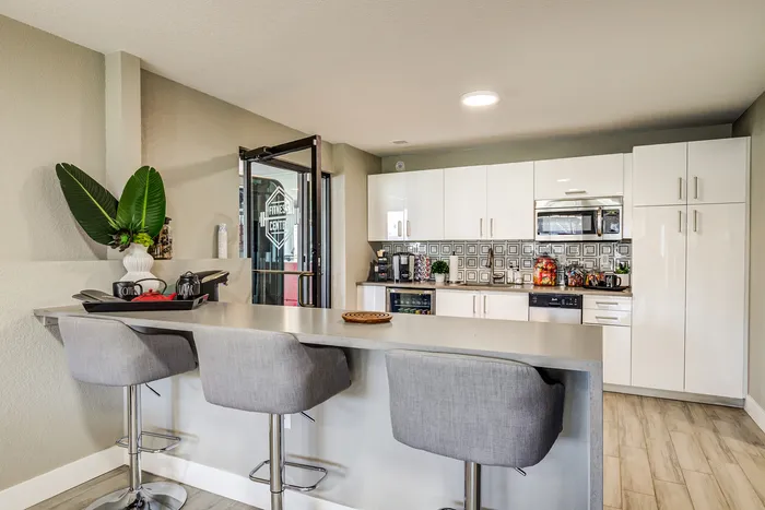 ReNew Foothills Stylish kitchen with elegant countertop, modern stools, and sleek white cabinetry.