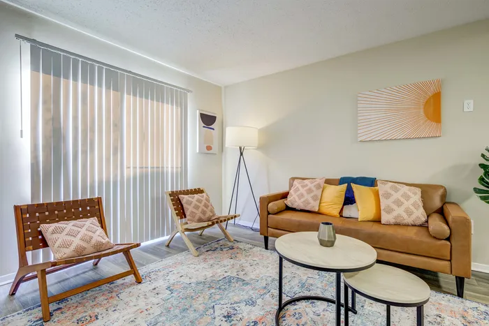 Bright living room with a stylish leather sofa, modern chairs, and decorative accents.