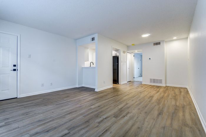 Inviting open-concept living space at ReNew on Cantrell with sleek laminate flooring, abundant natural light, and modern design.