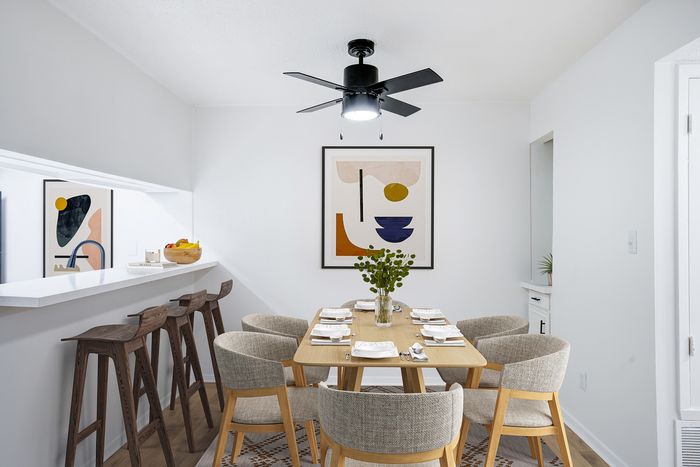 Chic dining area with modern art, stylish seating, and elegant bar stools, perfect for entertaining.