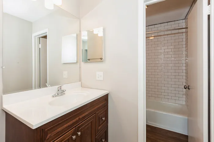 Bright and sophisticated bathroom design featuring a sleek white vanity, large mirror, and timeless subway tile shower.