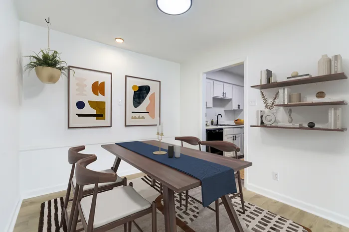 Chic dining area at ReNew on Cantrell with modern decor, stylish wooden table, and inviting view into a freshly updated kitchen.
