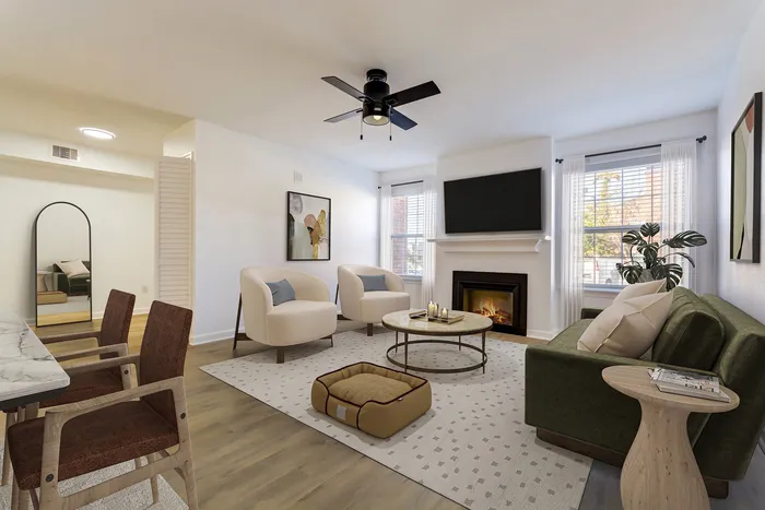 Inviting living room at ReNew on Cantrell with stylish decor, featuring a cozy fireplace, elegant seating, and a modern ceiling fan, perfect for relaxing.