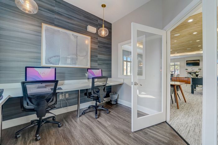 Modern home office with sleek workstations, comfortable chairs, and ambient lighting, seamlessly connected to a bright and inviting living space with stylish decor.