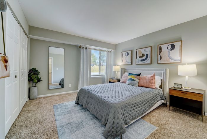 Inviting bedroom at ReNew White Marsh with plush carpeting, elegant bed set, and modern art pieces, perfect for relaxation.