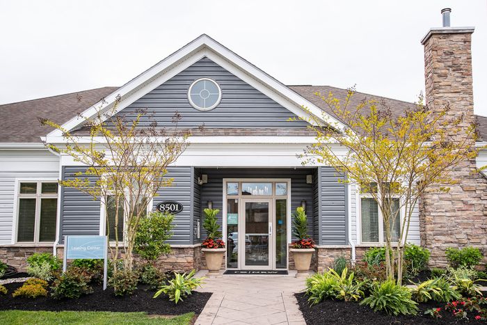 Charming leasing center exterior with elegant landscaping and inviting entrance.