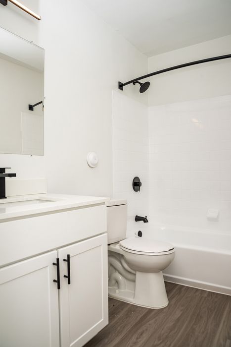 Contemporary bathroom at ReNew White Marsh with sleek fixtures, modern white vanity, and elegant wood flooring.